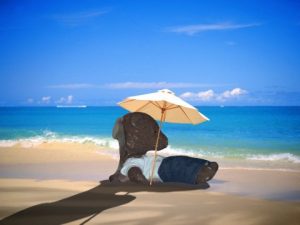 Bearsac lying under parasol on beach