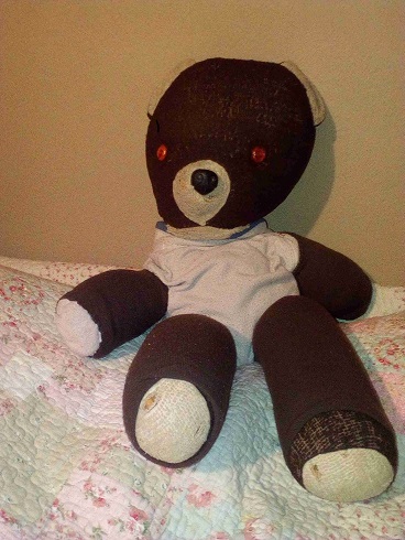 Old looking teddy bear in body stocking to preserve him