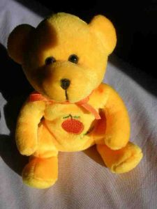 Yellow teddy with an apricot on its chest