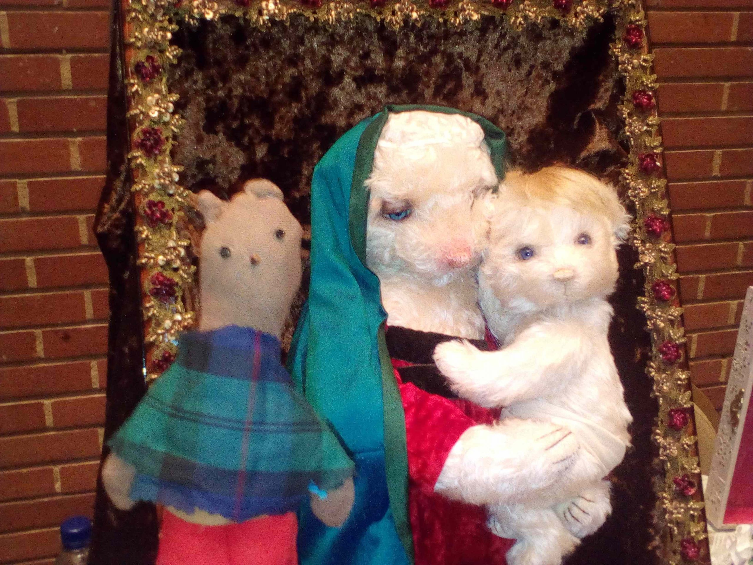 Mini-me version of Bearsac posing with Mary and baby Jesus teddy bears.