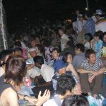 People sitting on ground waiting for fireworks.
