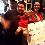 Bearsac and Debra with a man (Debra with poster saying 'The bear is back in town'.