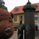 Bearsac beside the statue of writer August Senoa