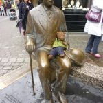 Bearsac sitting on the lap of Oscar Wilde (statue)