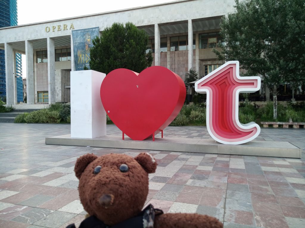 Bearsac in foreground of Tirana Opera House and I love Tirana sculpture