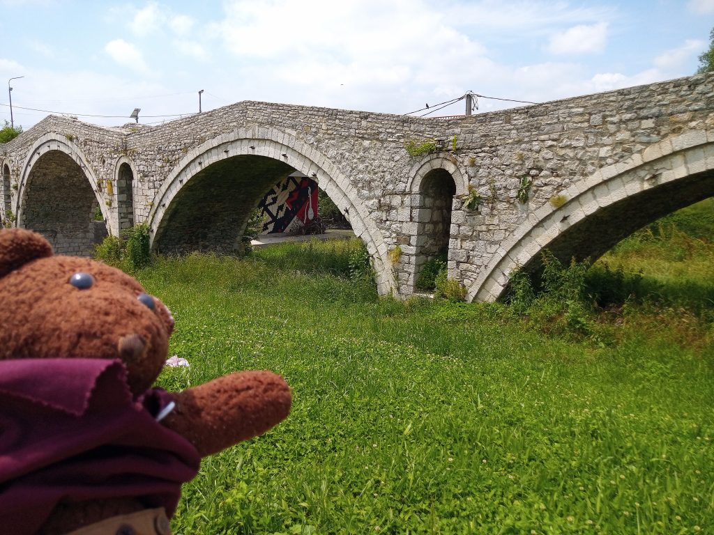 Bearsac in foreground of a very old stone bridge