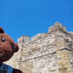 Bearsac the teddy bear in the forground of Larnaca Castle