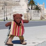 Bearsac the teddy bear in the foreground of Dar Al-Baroud Tower