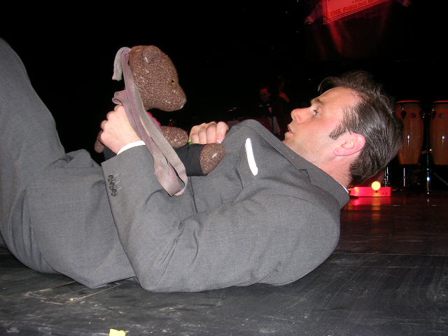 Tony Benedict lying on stage holding Bearsac
