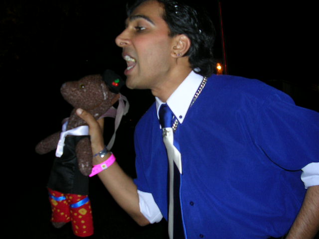 Shahbaz Chauhdrey shouting at crowd whilst holding Bearsac