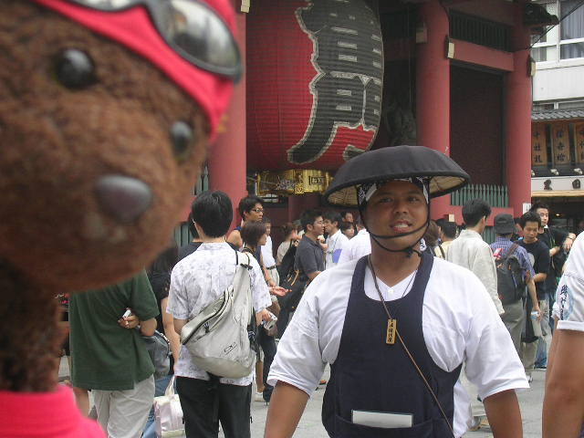 Bearsac in foreground of man wearing unusual hat