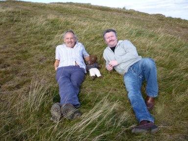 Clive Francis and Neil Capel sitting on grass with Bearsac between them