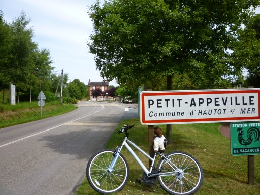 Bearsac on bicycle prompt up against place sign for Hautot-sur-Mer