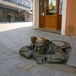 Bearsac sitting on worker statue, Bratislava.