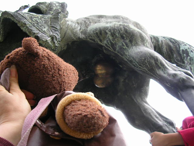 Bearsac looking up at the brass balls of a horse statue