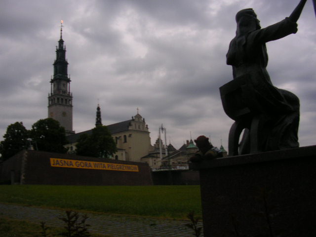 Bearsac sitting on a monument with JasnaGóra behind