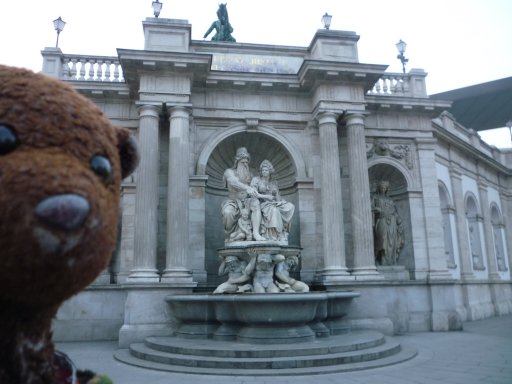 Bearsac and fountain with man and woman on a pedastool held by cherubs.