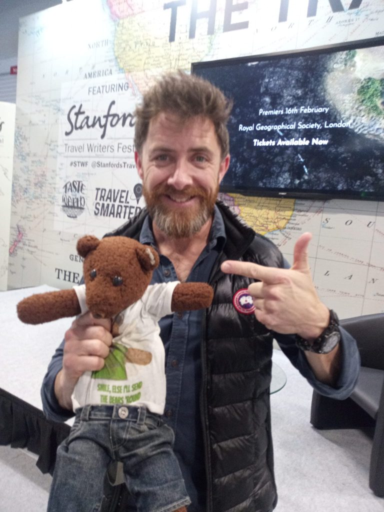 Aldo Kane holding and pointing at Bearsac the teddy bear