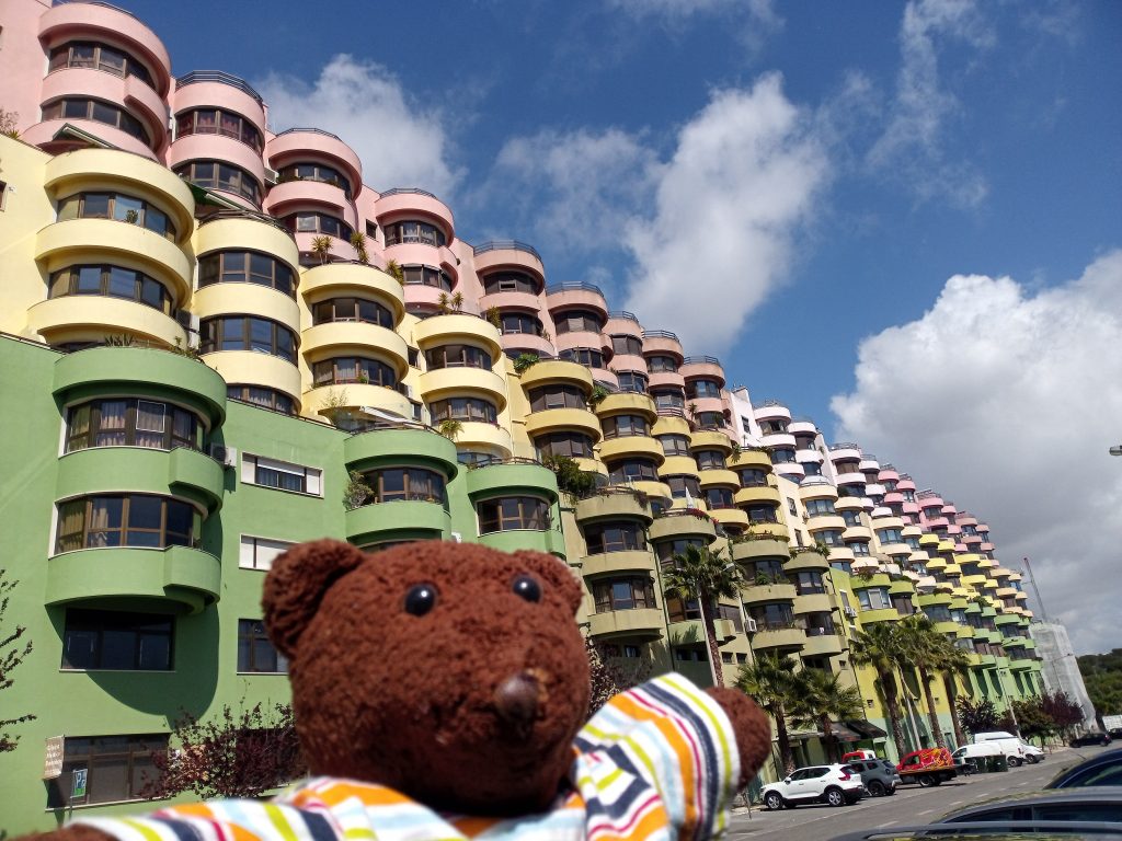 Bearsac in the foreground of a weird block of flats of pukey colours