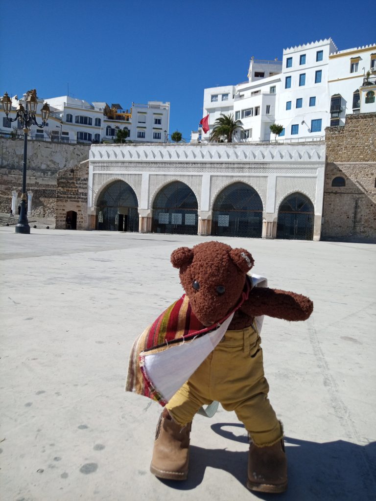 Bearsac the teddy bear in the foreground of a Tanger square
