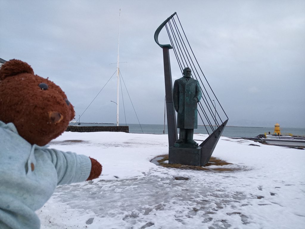 Teddy bear Bearsac in forground of the Einar Benediktsson monument