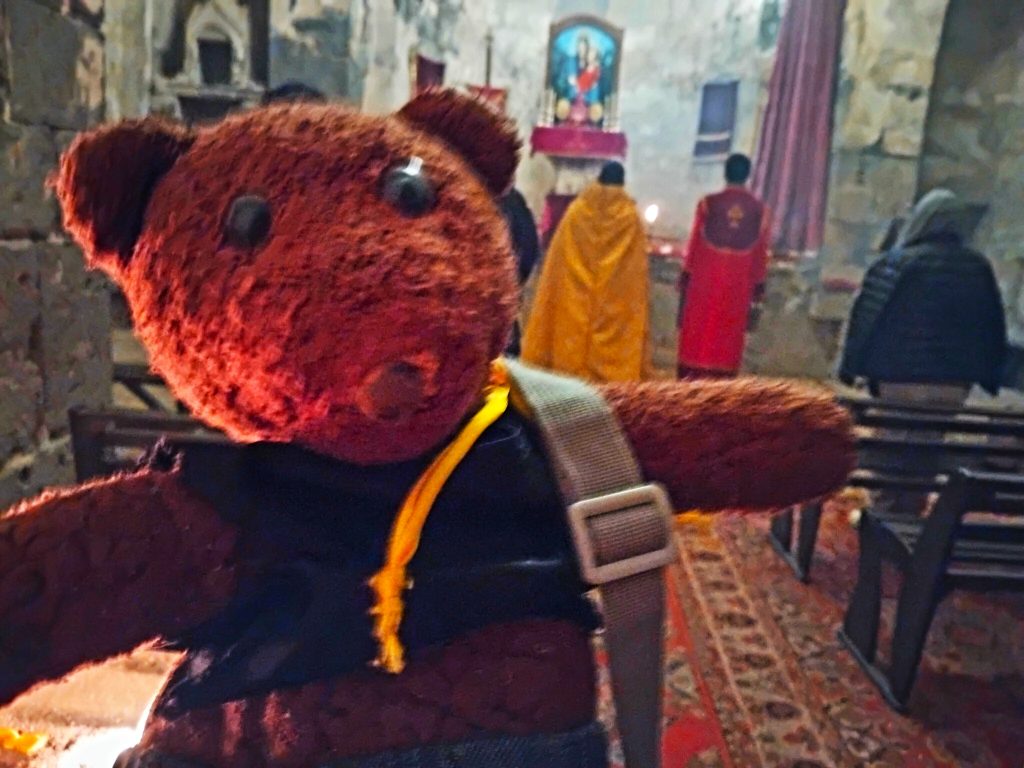 Bearsac the teddy bear inside a church