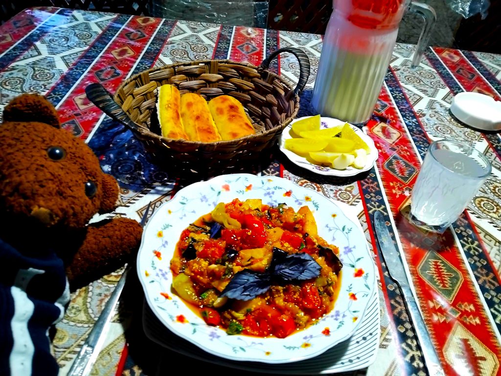 Bearsac the teddy bear with a plate of food.