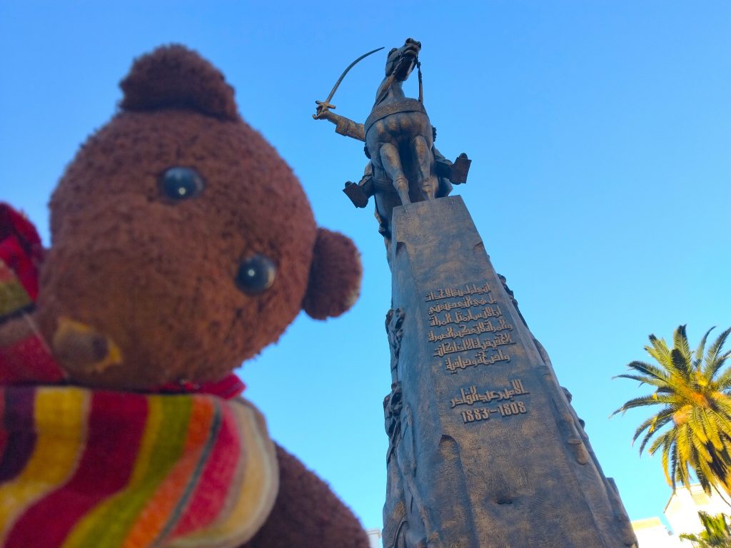 Bearsac the teddy bear in forground of bdelkader-ibn-Muhieddine monument