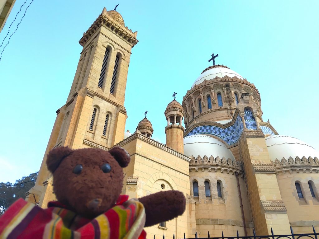 Bearsac the teddy bear in forground of a church