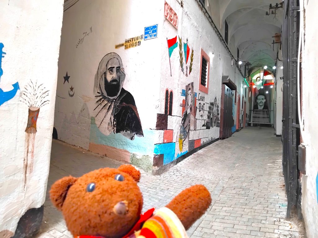 Bearsac the teddy bear in forground of wall art