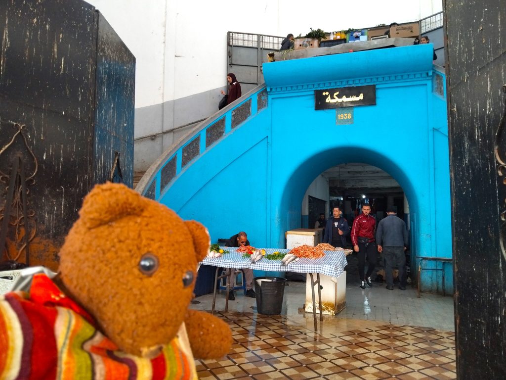 Bearsac the teddy bear in forground of a market stairway