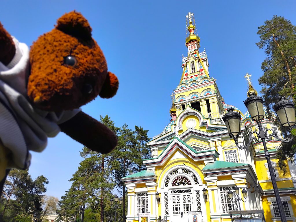 Bearsac the teddy bear in the forerground of a church