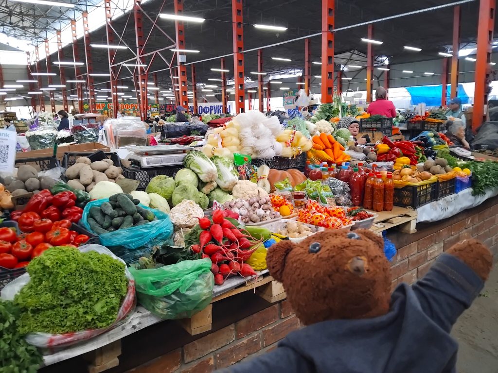 Bearsac the teddy bear in the forerground of a market stall