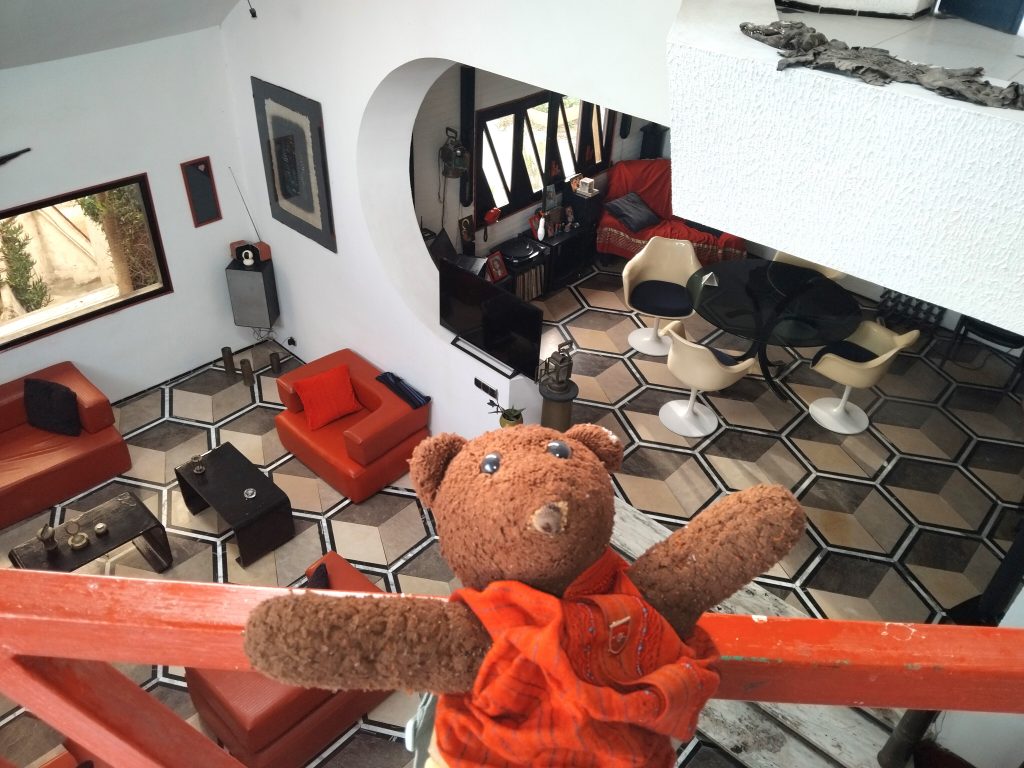 Bearsac the teddy bear in the forground of a sitting-room