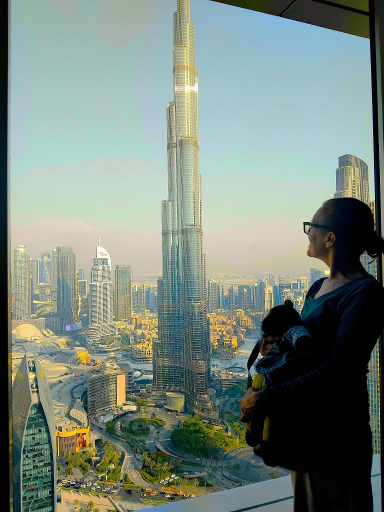 Bearsac the teddy bear and Debra looking out of a window at the skyscrapers