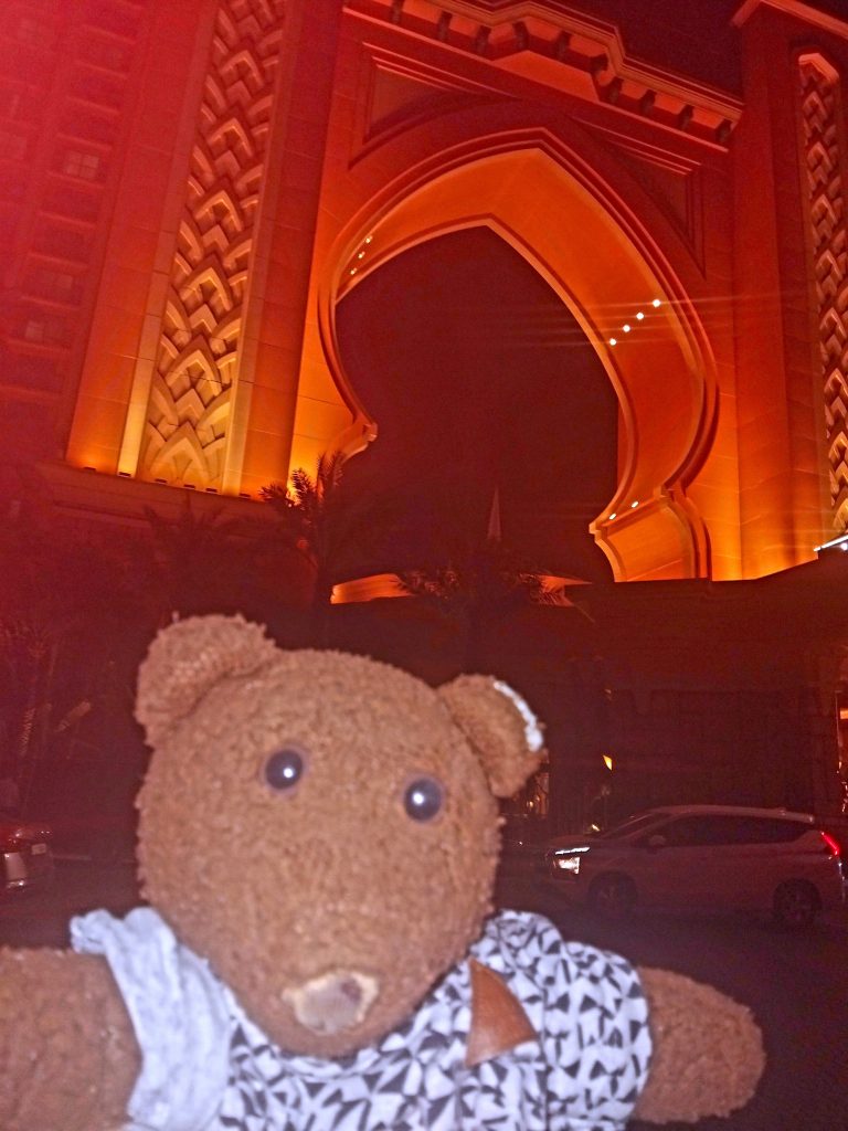 Bearsac the teddy bear in foreground of the hotel arch