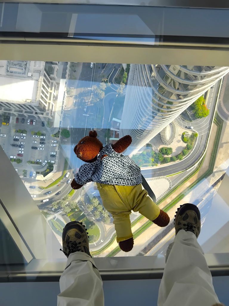 Bearsac the teddy bear lying on the glass florr of Burj Khalifa