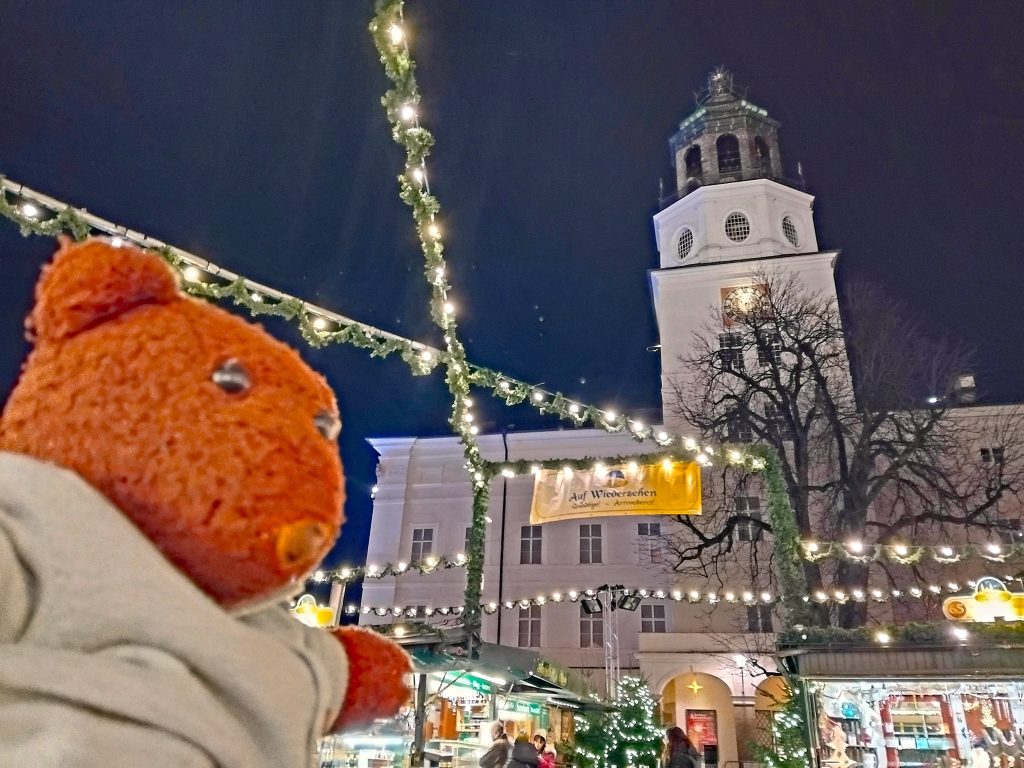 Bearsac the teddy bear in forground of Salzburg Glockenspiel