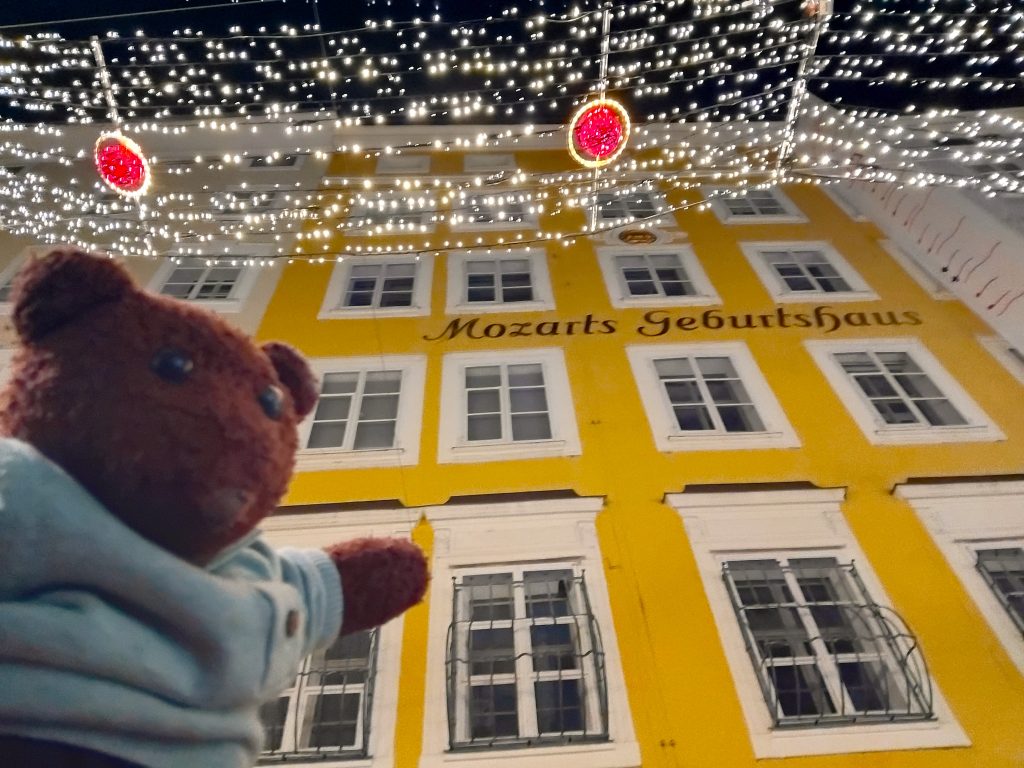 Bearsac the teddy bear in forground of Mozart House
