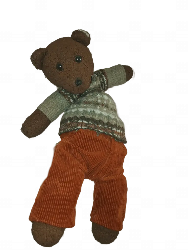 Bearasc the teddy bear wearing a green pattereed jumper and organge cordaroy trousers.