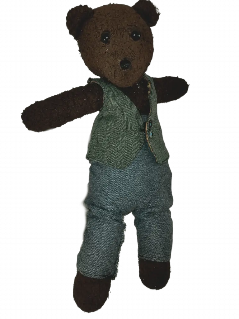 Bearasc the teddy bear wearing a greyish green waistcoat and grey tousers.