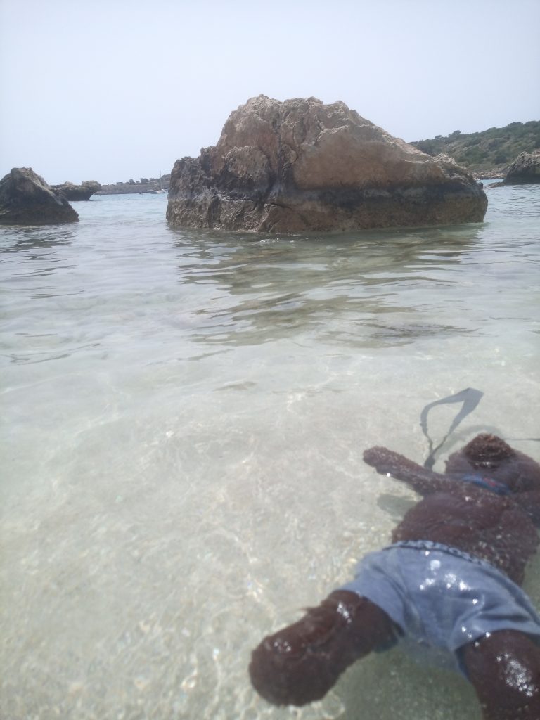 Bearsac the teddy bear floating in very clear sea water.