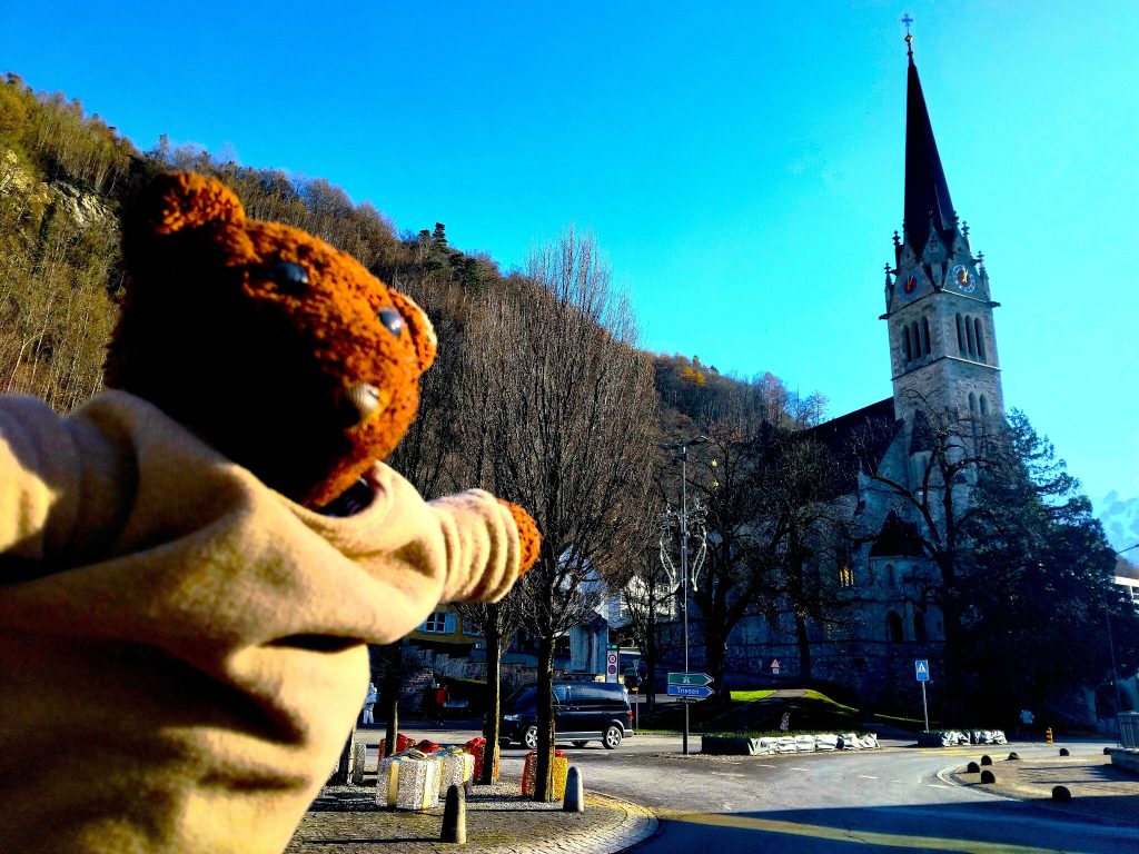 Bearsac the teddy bear in forground of Vaduz Cathedral