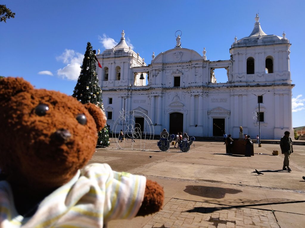 Bearsac the teddy bear in foreground of a church.
