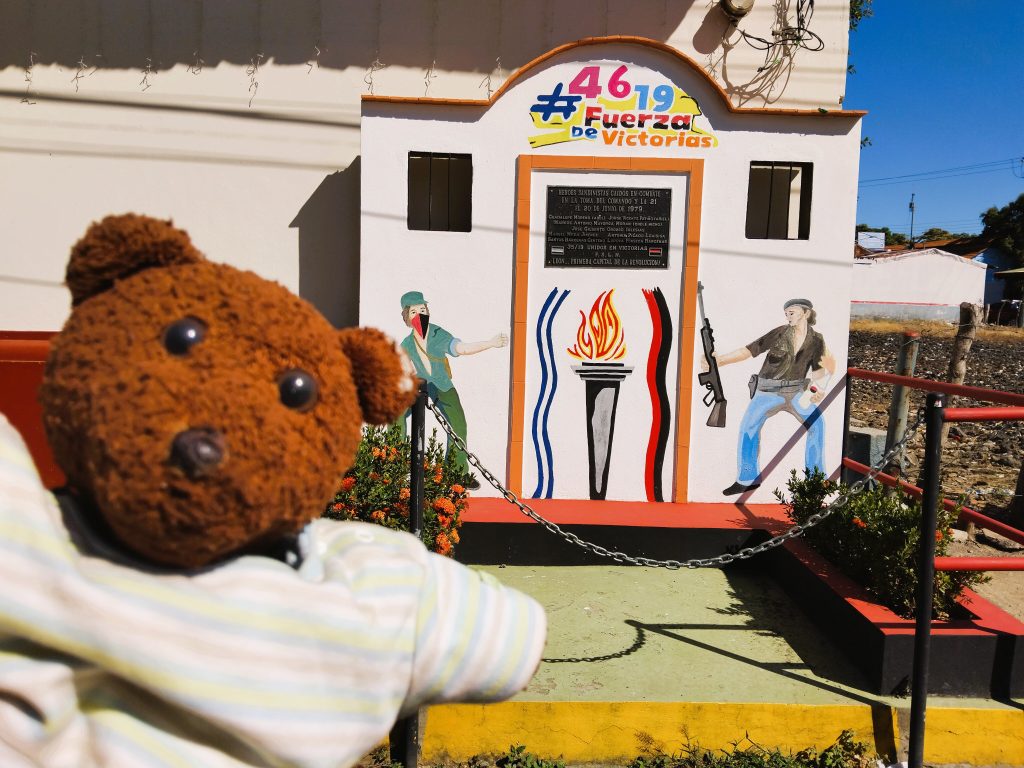 Bearsac the teddy bear in foreground of victory monument.