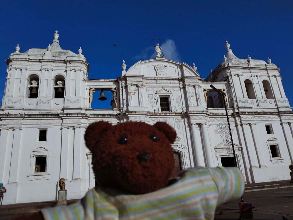 Bearsac the teddy bear in foreground of a church.