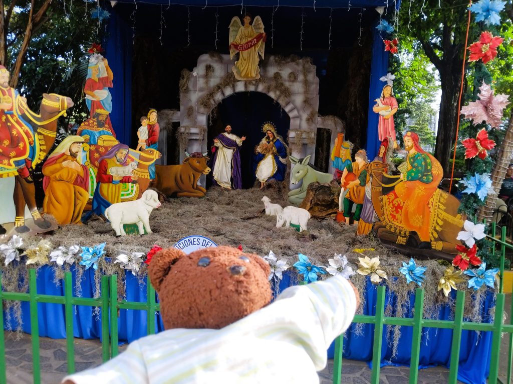Bearsac the teddy bear in foreground of an nativity display.