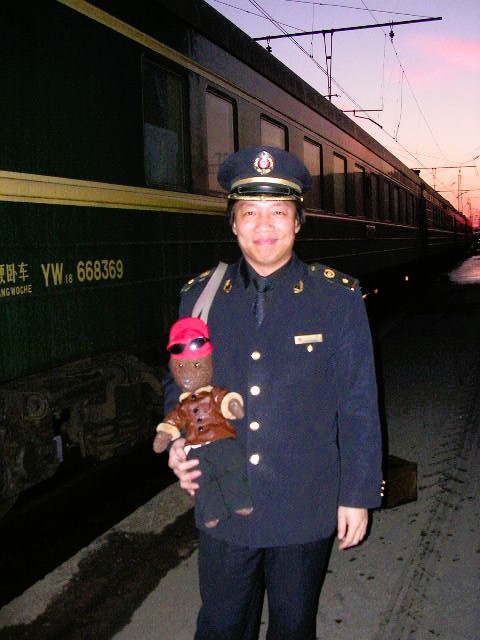 Bearsac being held by a train guard outside of the train.