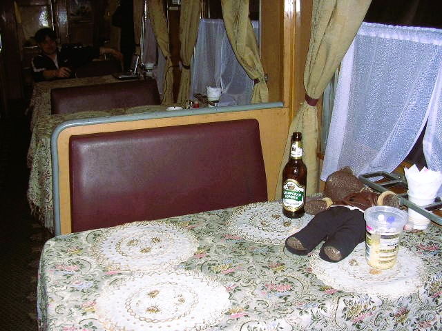 Bearsac sitting ona table in the train restaurant.